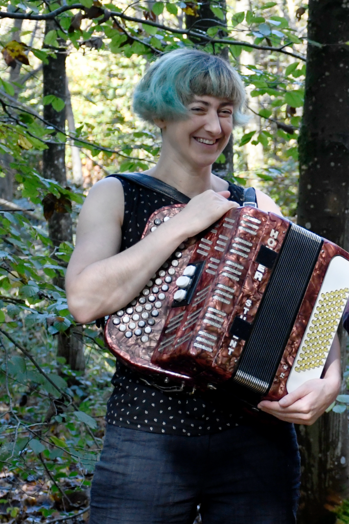 Nahaufnahme von Angela am Akkordeon im Wald, Originalgrösse